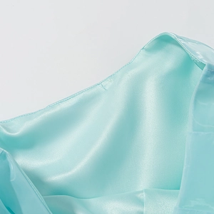 Vue macro détaillée de la texture du tissu satin bleu clair et plis en soie