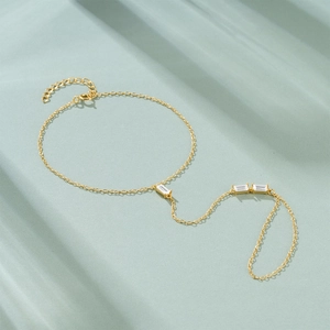 Detailed view of a gold-plated finger bracelet featuring three elegant zircon stones