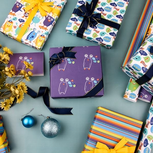Cartoon gift wrapping paper with monster illustrations and colorful stripes for birthdays