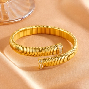 Détail du bracelet à ressort doré avec extrémités en cristal sur soie champagne