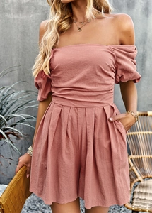 Pink off-the-shoulder romper with puff sleeves and smocked waist shown in lifestyle setting