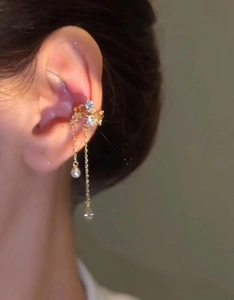 Detail of gold-plated flower ear cuff with zircon tassel and pearl drop on model