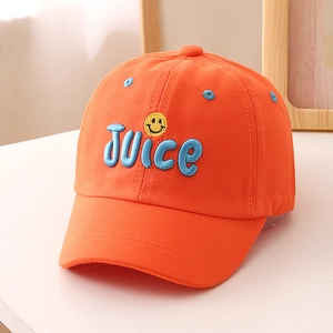 Detail der orangefarbenen Baumwollkappe mit blauer JUICE-Stickerei und Smiley-Aufnäher