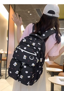 Detail of black fabric backpack with cute white bear prints and multi-pocket structure