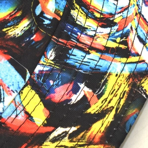 Détails macro du motif graffiti et des coutures renforcées sur le chapeau bob réversible
