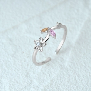 Macro shot of silver floral ring with colorful orange and pink gemstones and zircon detail
