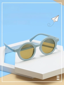 Detail view of retro round kids sunglasses in light blue matte frame and amber yellow lenses