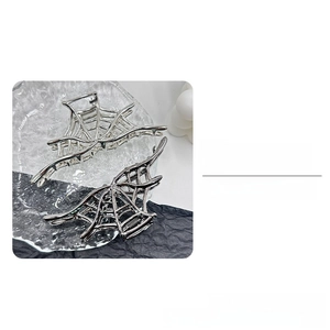 Detailed view of metal spider web hair claws in silver and gun-black finish
