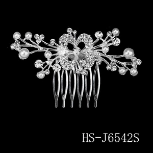 Detailed close-up of silver bridal hair comb with crystals and pearls on black background