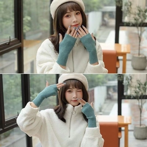 Detail of blue knitted fingerless gloves showing warm textured wool on female model
