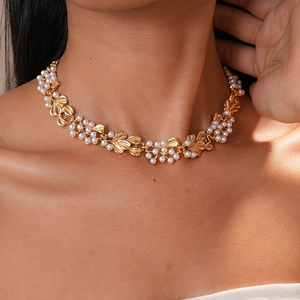 Detail showing vintage gold leaf design and faux white pearls on an elegant necklace