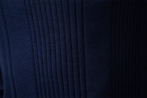 Macro view of navy blue ribbed knit fabric texture on premium polo sweater