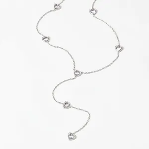 Macro shot of silver Y-shaped stainless steel necklace with heart-shaped zircon charms