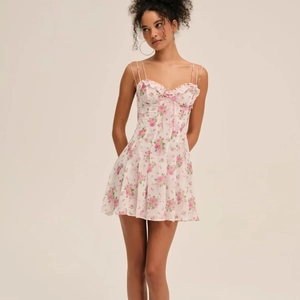 Floral spaghetti strap mini dress with pink rose print and ruffled hem detail