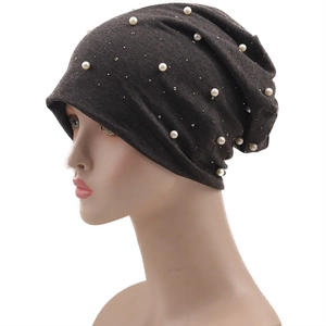 Détail d'un bonnet en maille gris foncé avec perles élégantes et strass brillants