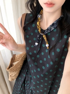 Detail of fabric print heart pendant necklace with wood beads and polka dot scarf