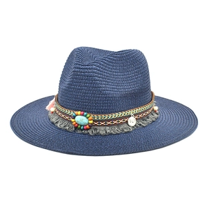 Detail of navy straw fedora with ethnic beaded band, turquoise stone, and grey tassels