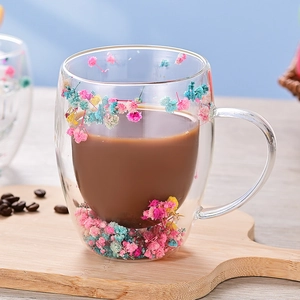 Double-walled borosilicate glass cup featuring colorful dried flowers and handle on wood tray