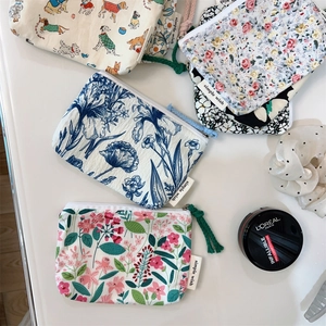Close-up of floral canvas mini pouches with zippers and simple wish labels for makeup