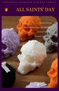 Detail of floral embossed skull candles in various colors with fabric tags on wood