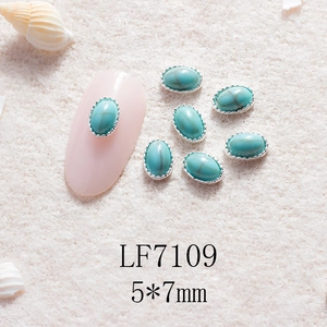 Détail de gemme turquoise 5x7mm pour nail art avec bord festonné argenté sur ongles roses
