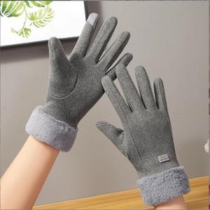 Detail of gray winter gloves with faux fur cuffs and touch screen finger tips on hands