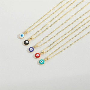 Detailed view of evil eye pendants in white, black, blue, and red with gold chains