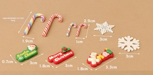 Macro view of miniature Christmas resin charms including snowflakes and holiday signs