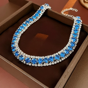 Three-row rhinestone necklace with blue crystals in a brown jewelry box view