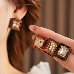 Detailed view of amber leopard resin earrings with central rectangular gemstones