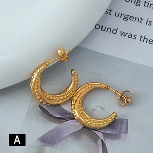 Modern gold C-shaped hoop earrings with beaded texture on minimalist white background