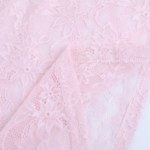 Primer plano del tejido de encaje rosa con detalle del patrón floral y las costuras