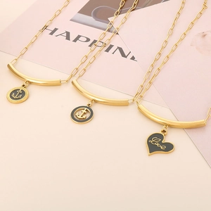 Macro view of gold-plated paperclip chain necklaces with enamel anchor and heart charms