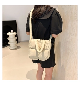 Quilted puffer crossbody bag in off-white fabric shown on a model for scale and fit