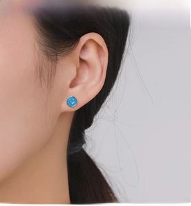 Gros plan de boucles d'oreilles cœur en argent S925 avec émail bleu et détail vert