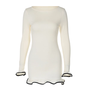Detail of white long sleeve knit dress featuring contrasting black ruffle hem and cuffs