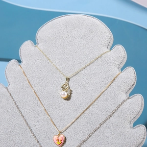 Detail of elegant necklaces including swan pendant on grey velvet flame board display