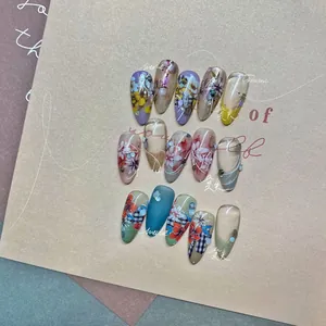 Detailed close-up of floral and plaid press-on nails with 3D rhinestones and pearls