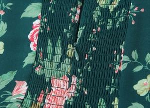 Detail of floral printed dress featuring elastic smocked fabric and an invisible zipper