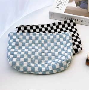 Macro shot of knitted checkerboard pouches in blue-white and black-white yarn patterns