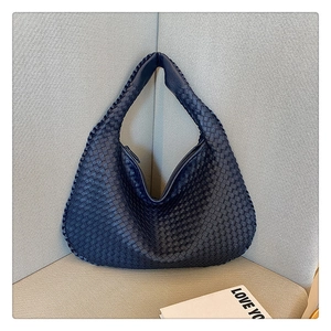 Detail view of navy blue woven leather hobo bag with zip closure and rich texture