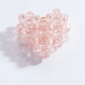 Close-up of a handmade pink crystal beaded heart pendant with multifaceted glass beads