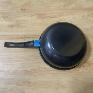 Rear view of mini non-stick frying pan showing black bottom and blue handle connector