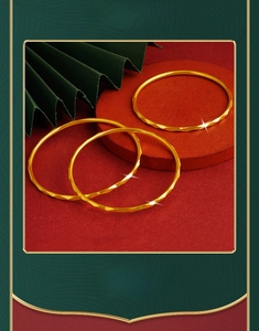 Close-up of a three-piece gold copper alloy bangle set with geometric diamond facets