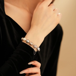 Close-up of multi-colored pearl bracelet with sparkling pavé magnetic clasp and safety chain