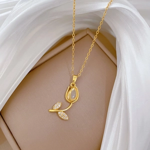 Close-up of golden tulip necklace with cat eye stone and rhinestones on silk background