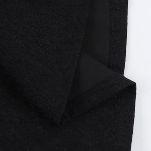 Dettaglio del tessuto jacquard nero con trama a rilievo e fodera interna liscia cucita