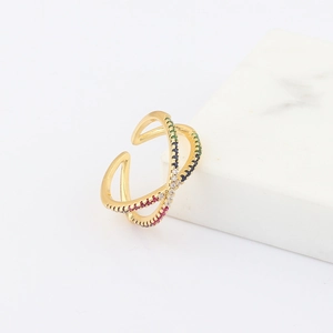 Macro detail of golden crisscross ring featuring inlaid multi-colored zircon stones
