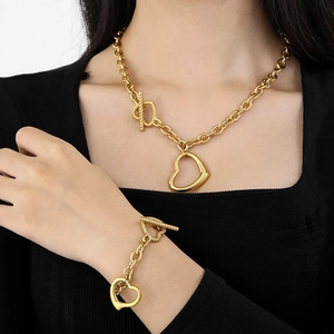 Detail of gold titanium steel heart necklace and bracelet set with toggle T-bar closure