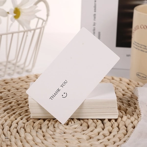 White cardboard jewelry display cards with Thank You smile print and earring holes